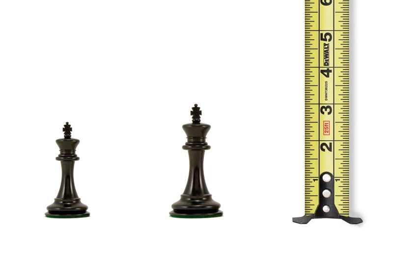 Two black chess king pieces of different sizes next to a measuring tape displaying their heights between 2.36 to 3 inches.