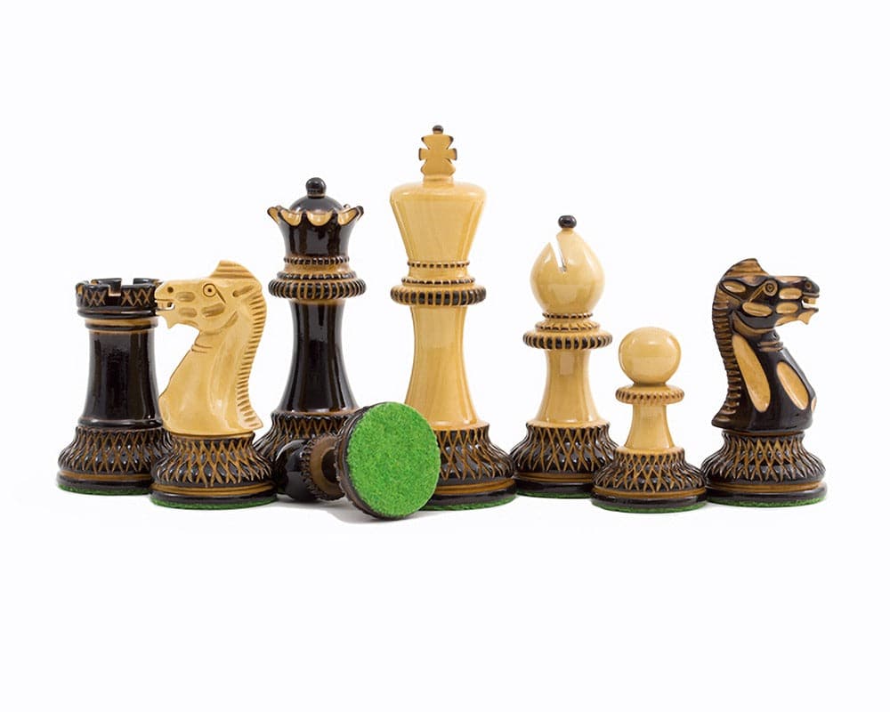 Burnt Parker chessmen with intricate carving, including 4-inch king, on white background. Luxurious Staunton style in dark and golden tones.