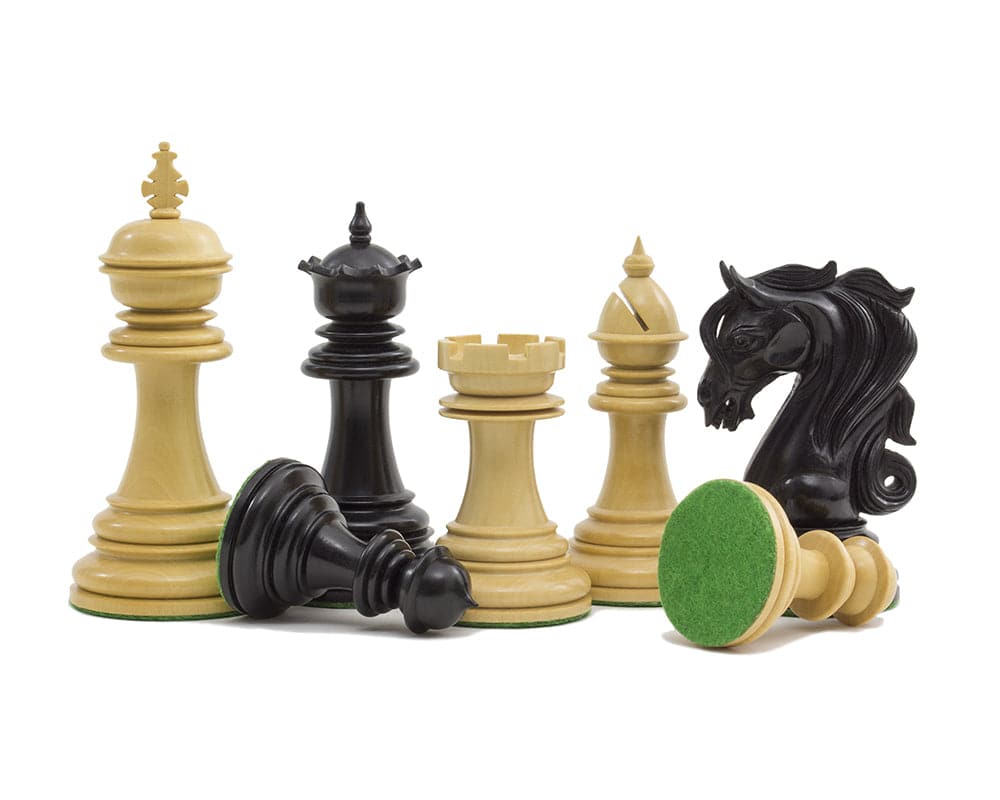 The Kingsgate Ebony Chessmen set with 4.25 inch King, intricately carved knights, and weighted pieces on green cloth bases.