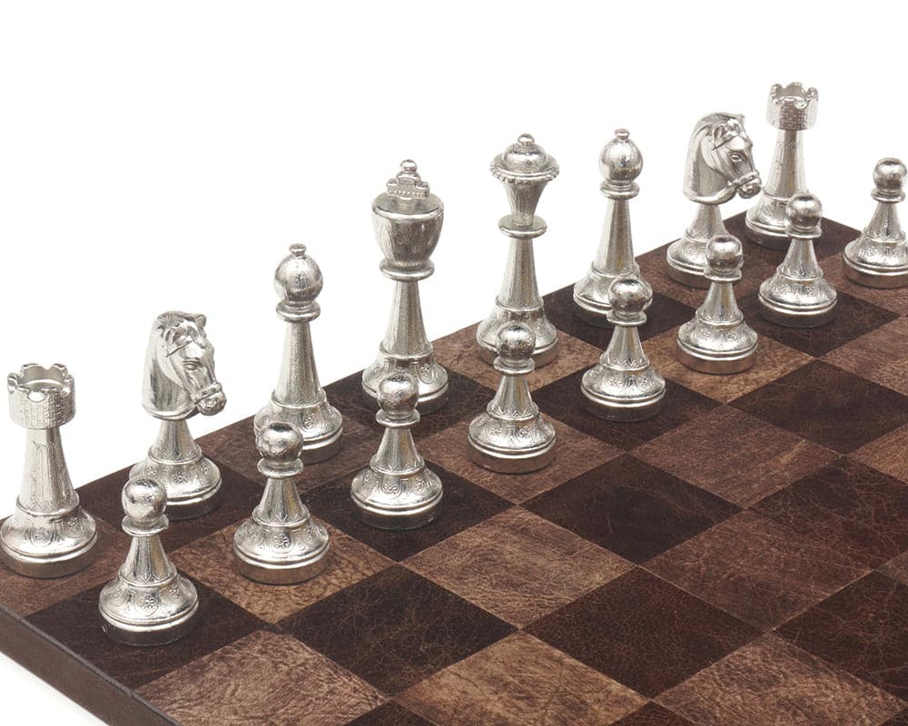 The Messina Gold and Silver Plated Italian Chessmen displayed on a wooden chessboard.