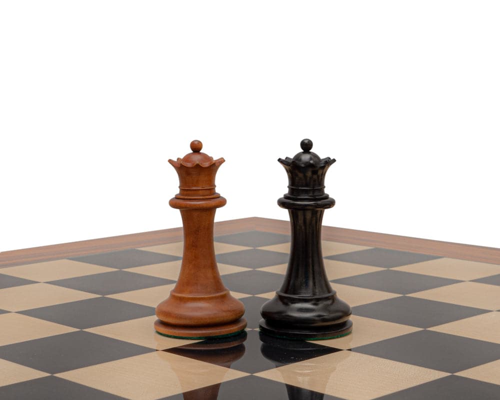 Reproduction Staunton Chessmen 1849 king pieces in antiqued boxwood and ebony on a chessboard.