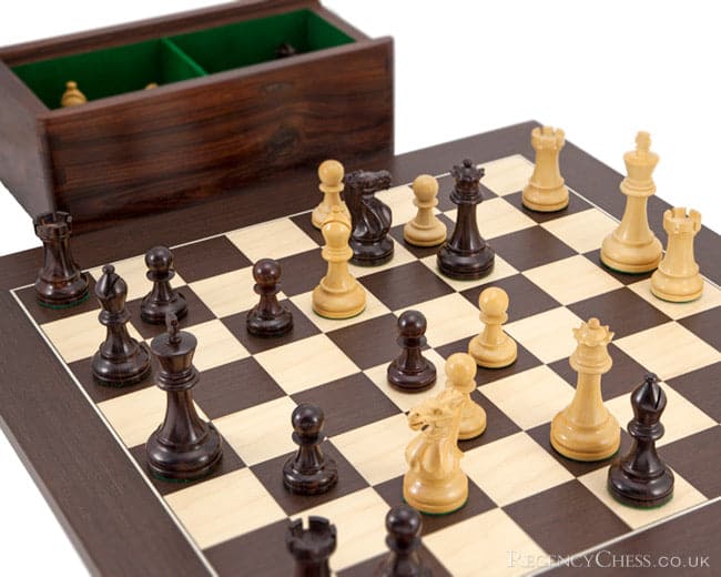 Rosewood and Wenge Deluxe Chess Set with hand-turned rosewood chessmen on a 20-inch wenge and maple board, shown with storage case in background.