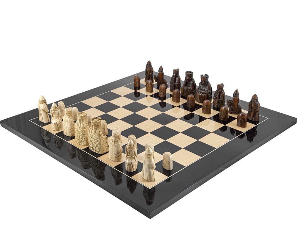 The Isle of Lewis Black Gloss Chess Set on a black anegre chess board featuring detailed and historic chess pieces.