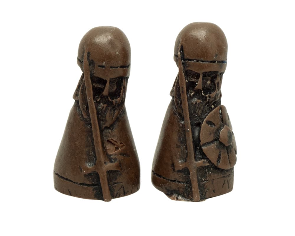 Two intricately designed Viking game pieces from Hnefatafl - The Viking Game Deluxe Edition set.